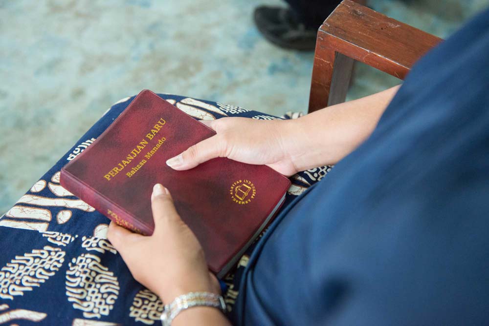 woman holds her Bible